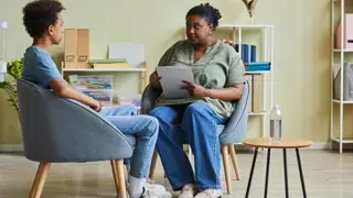 a serious looking social worker speaking to a young man in care seventyfour adobestock 512013243