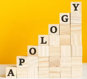the word apology spelt out in wooden blocks arranged in an ascending diagonal maks lab adobe stock 437758464