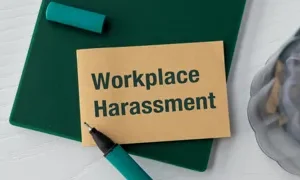 the words workplace harassment written on a card sitting on a clipboard on a desk pawel adobe stock 1116450926