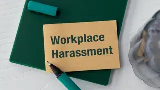 the words workplace harassment written on a card sitting on a clipboard on a desk pawel adobe stock 1116450926